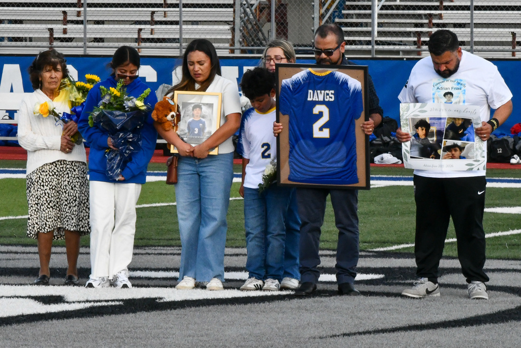 Photo of adults holding flowers, a picture and a jersey