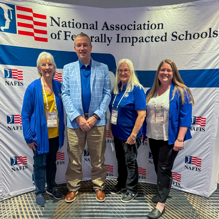 a group of people smiling in front of a backdrop
