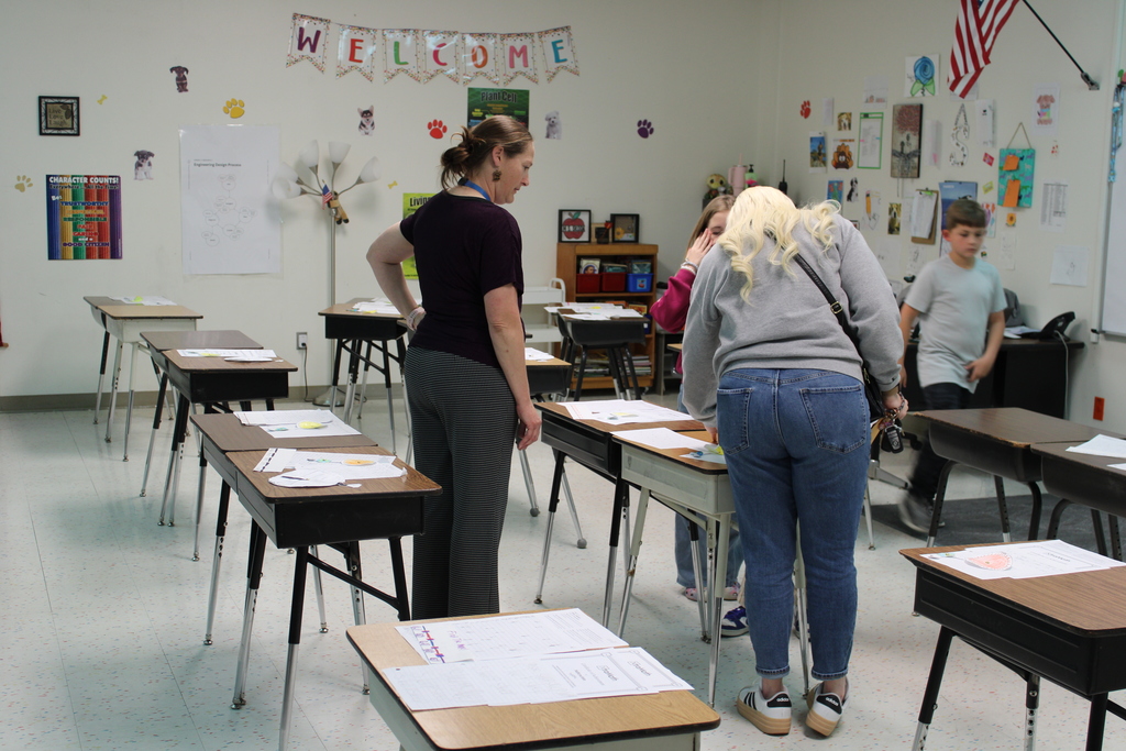 Parents and staff in classroom discussing students