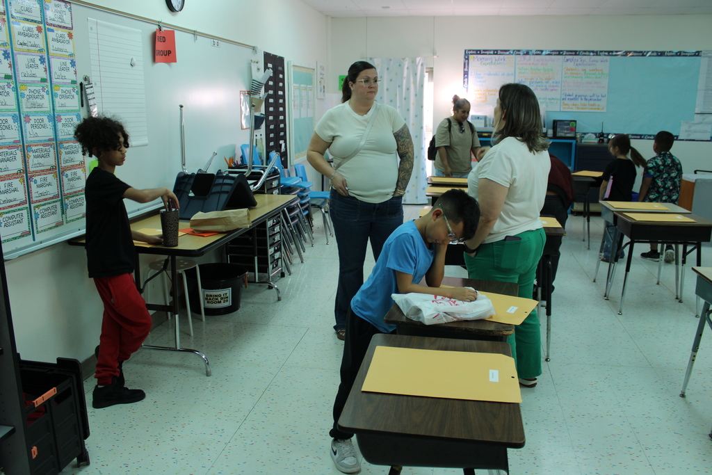Parents and staff in classroom discussing students