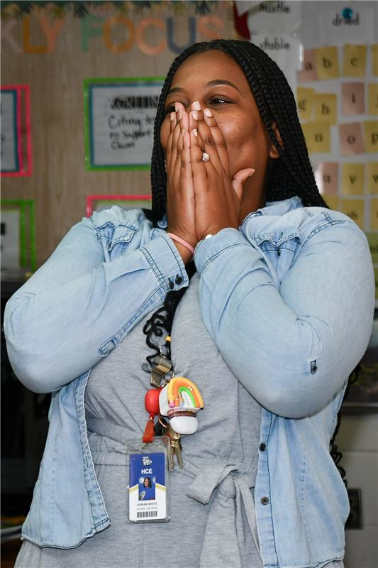 Woman in shock covering mouth with hand in classroom