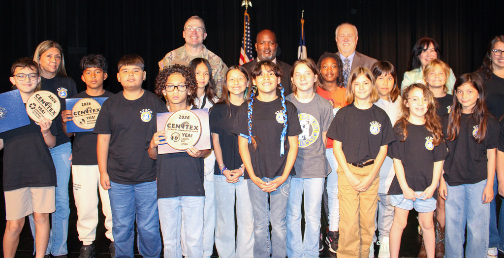 A group of students and adults smiling and holding awards