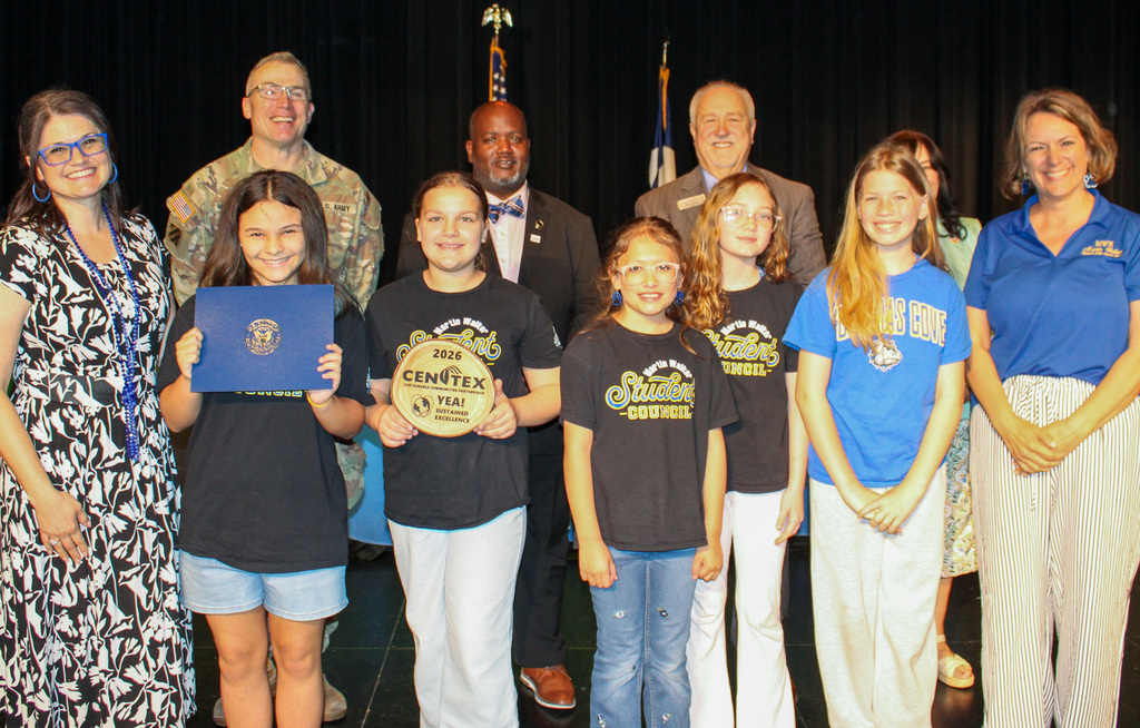A group of students and adults smiling and holding awards