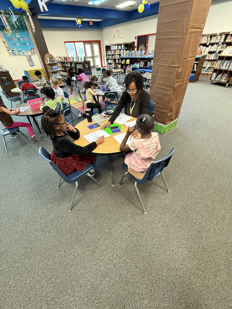Ms. Hart helping students stamp their dandelion