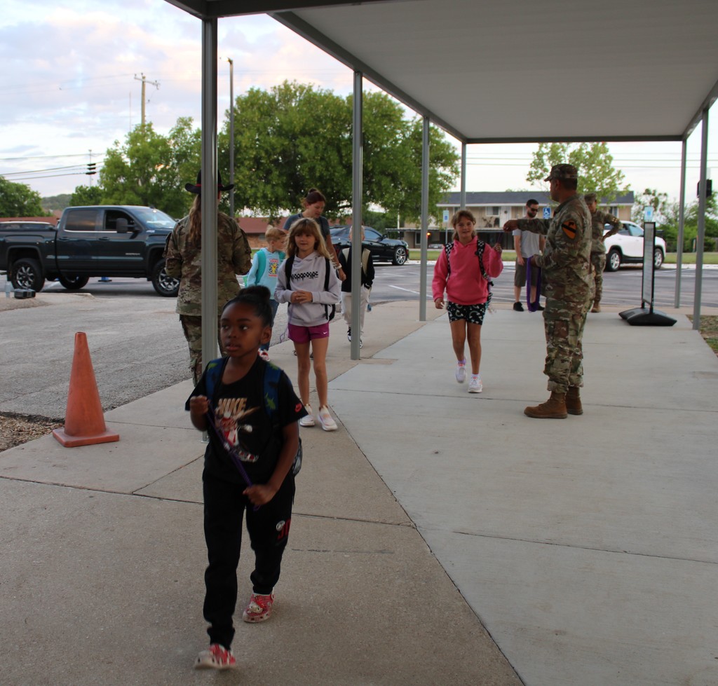 Soldiers hand out beads to students in the morning for purple up day