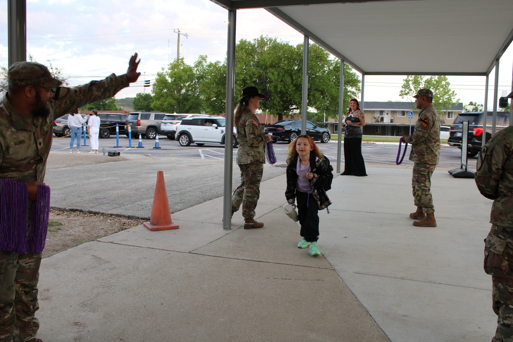 Soldiers hand out beads to students in the morning for purple up day