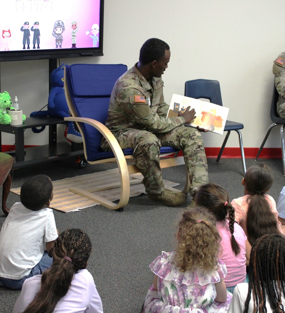 Service member reads to kinder in library