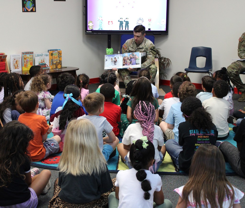 Service member reads to kinder in library