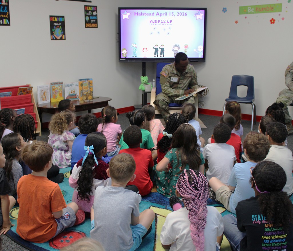 Service member reads to kinder in library