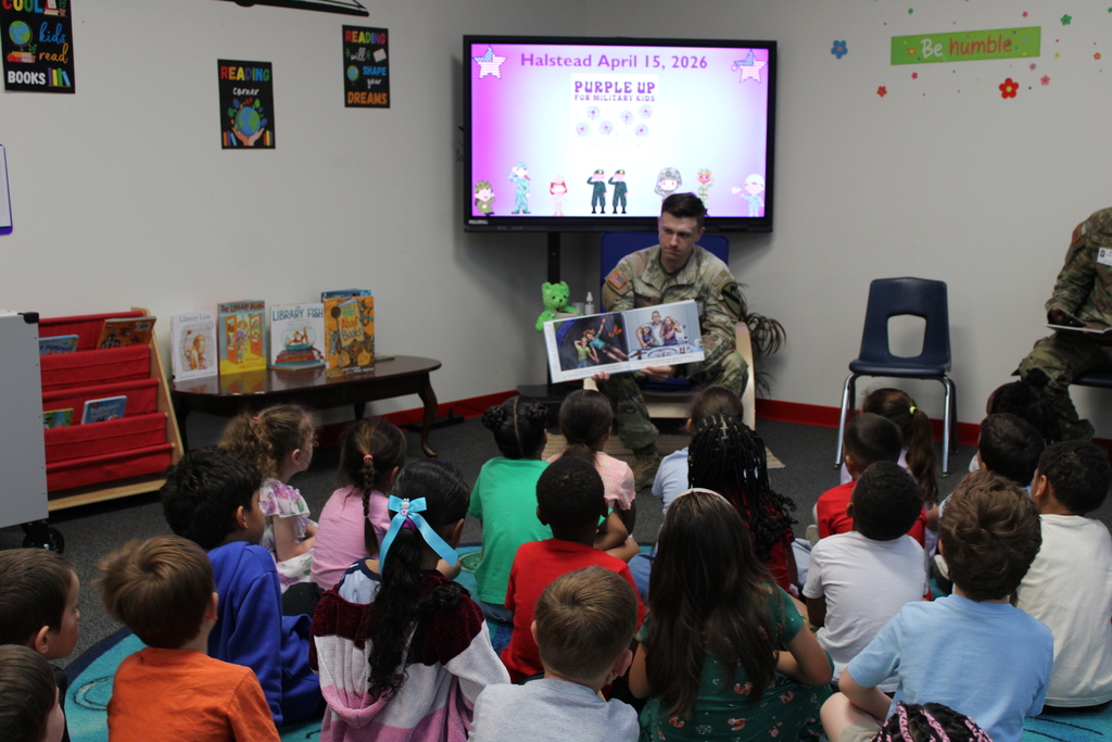 Service member reads to kinder in library