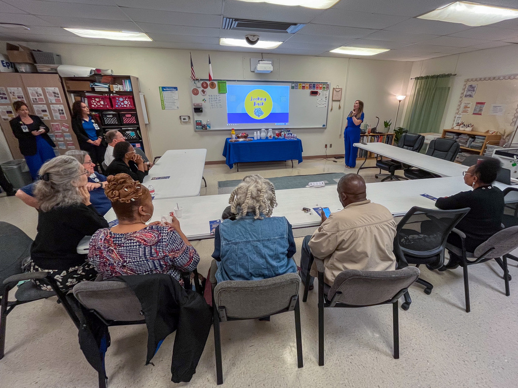 A group of people in a room with a presenter