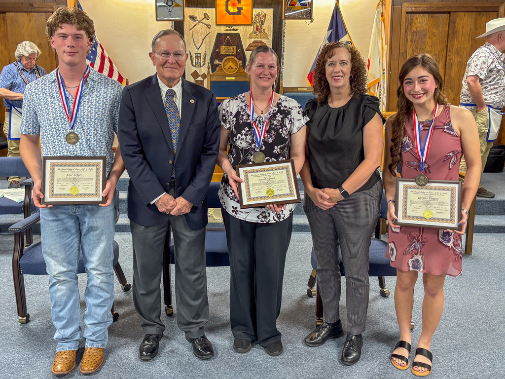 A group of people smiling and holding awards