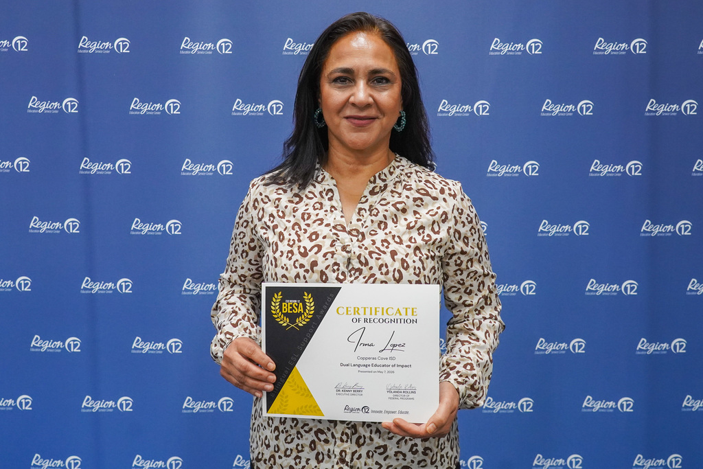 Woman holding an award, smiling in front of a backdrop