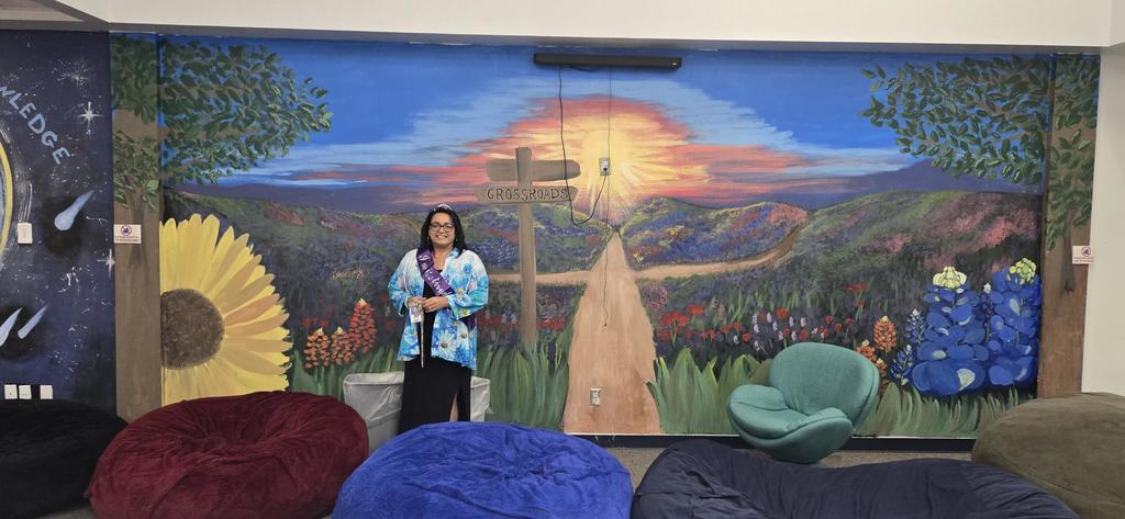 Mrs. Smith in front of mural she painted for 300 room