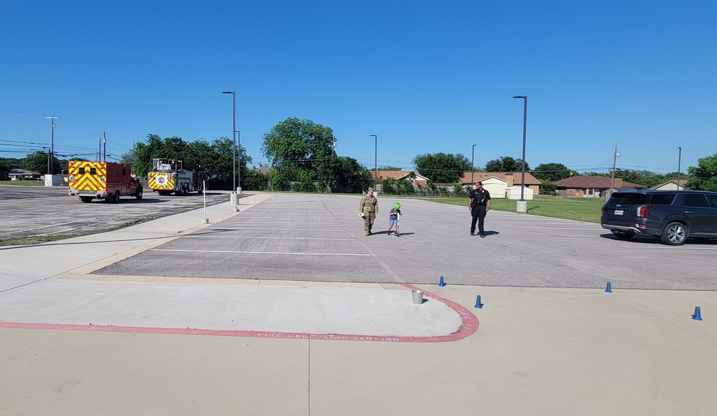 Student on student rides towards finishing line with service members and police officer