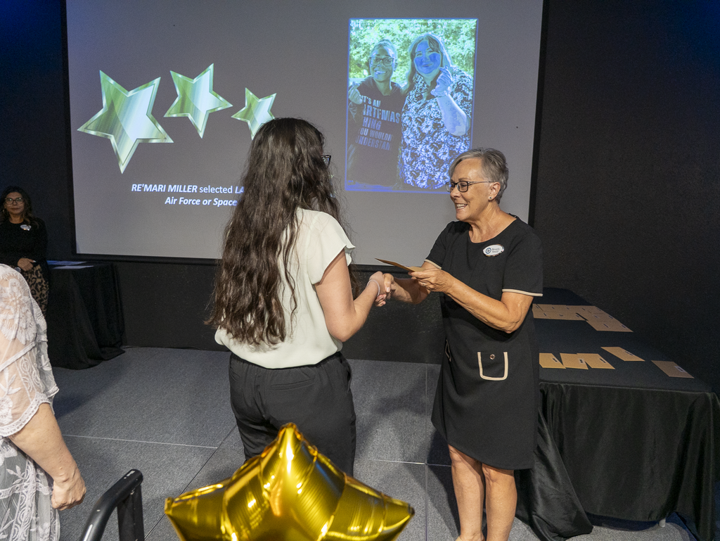 Student receiving award from woman on a stage