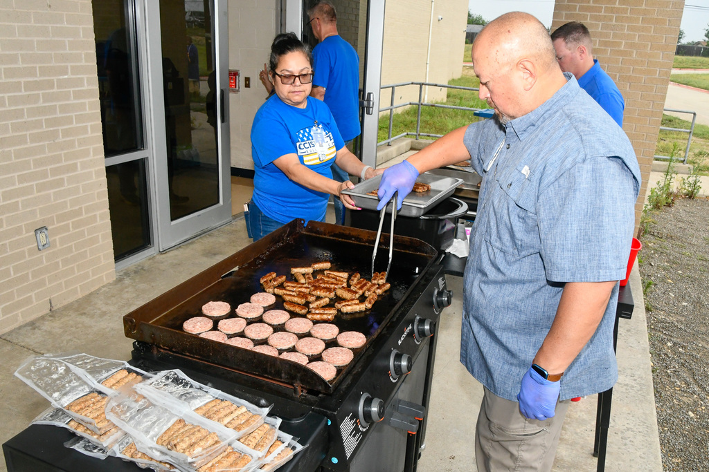 Man cooking sausage on a griddle