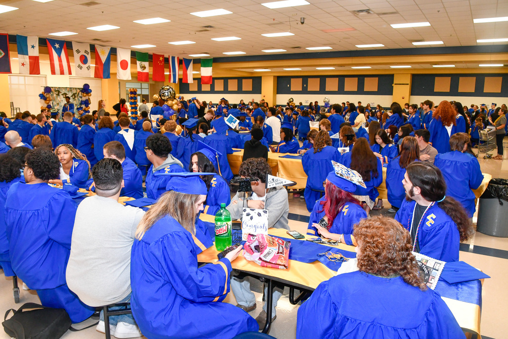 A cafeteria with students in caps and gowns
