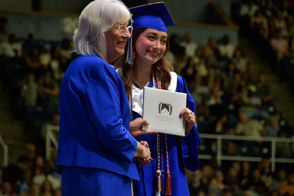 Woman and a student smiling while holding a diploma