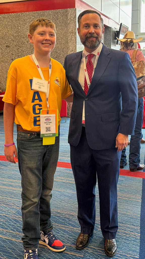 Man and teenager smiling in front of a wall