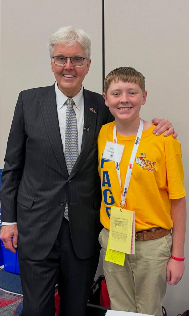 Man and teenager smiling in front of a wall