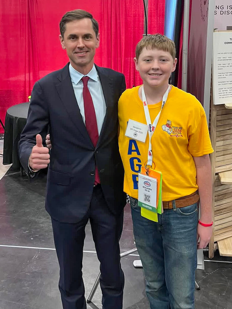 Man and teenager smiling in front of a wall