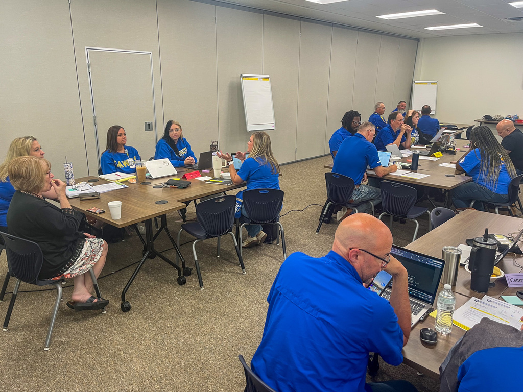 People talking at tables around a training room