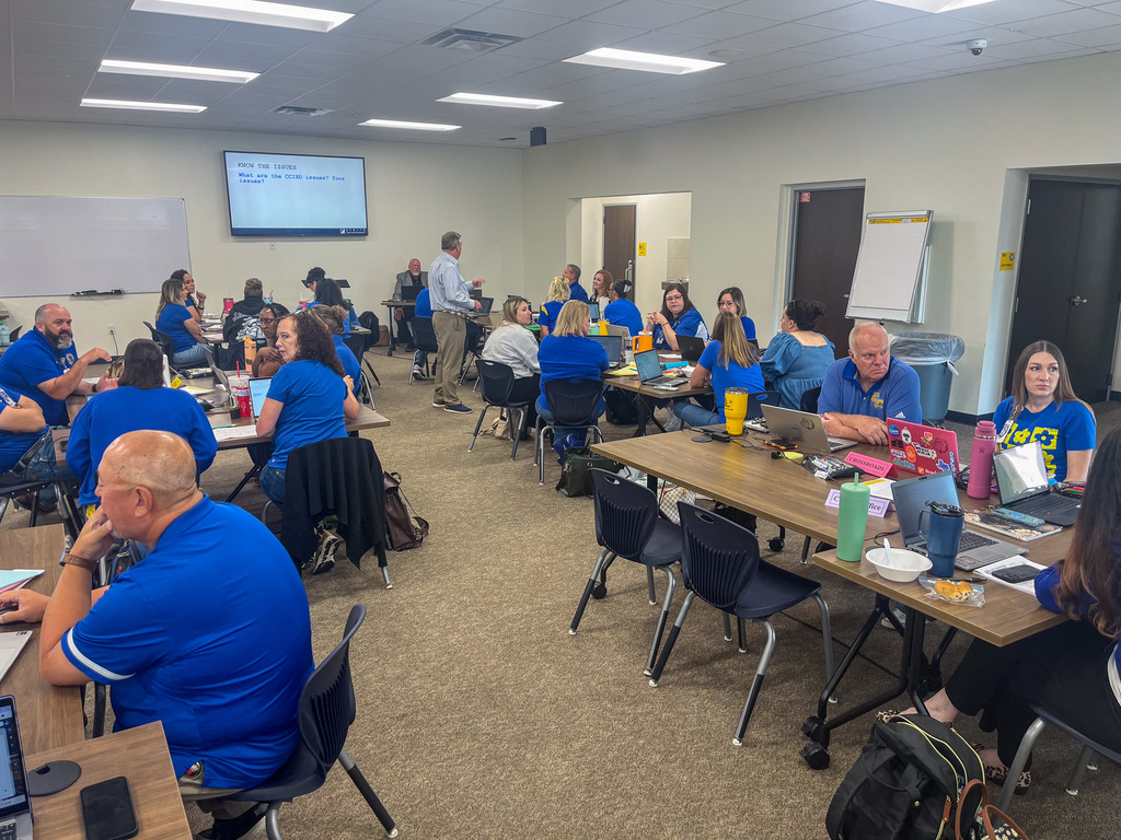 People talking at tables around a training room
