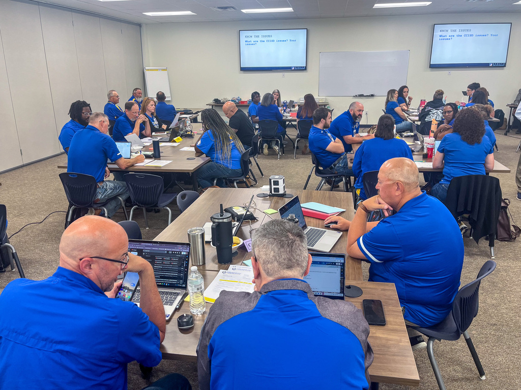 People talking at tables around a training room