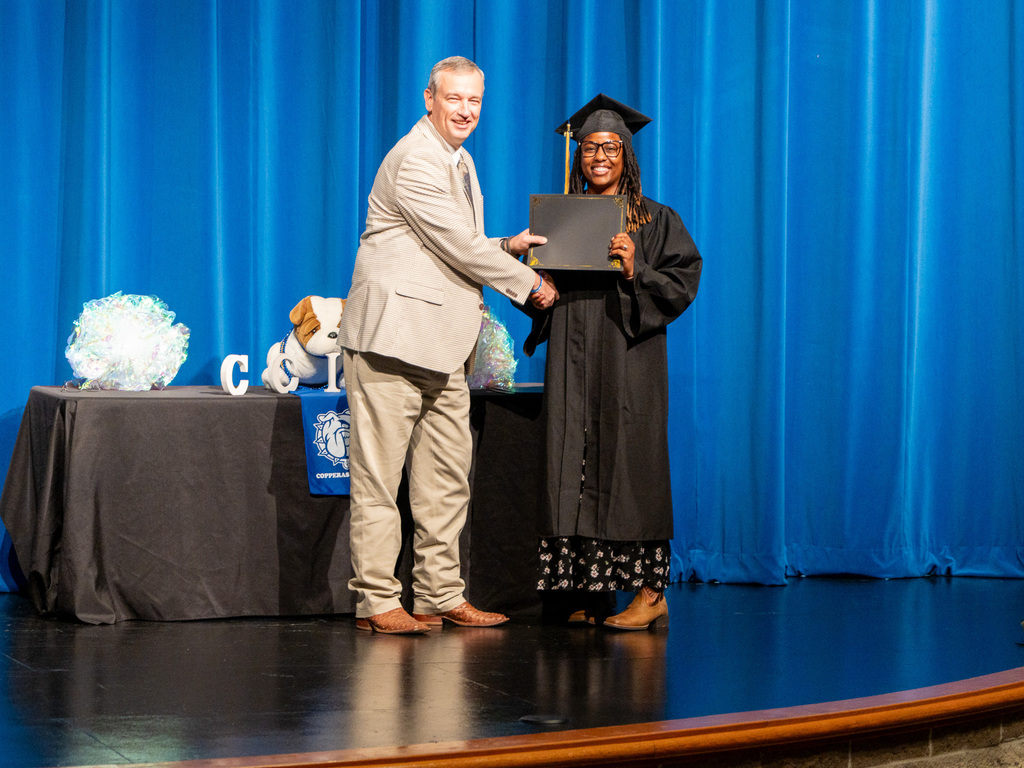 Man, woman smiling and holding certificate