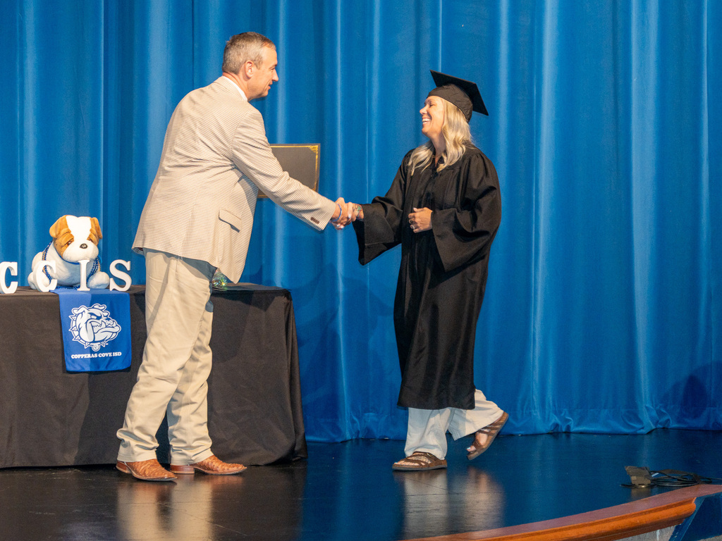 Man, woman shaking hands on a stage