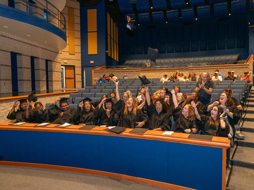 Graduates tossing caps into the air