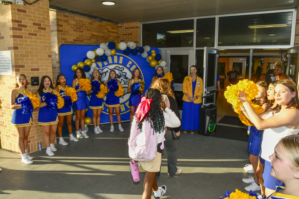 Students walking in with cheerleaders welcoming them