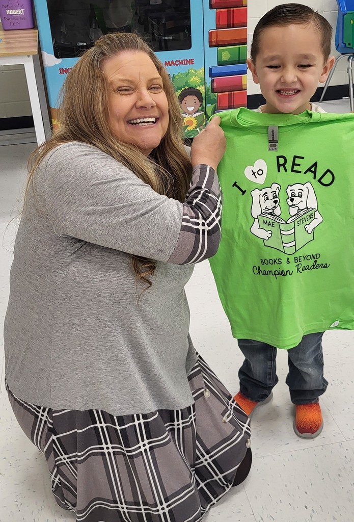 Student with teacher holding shirt