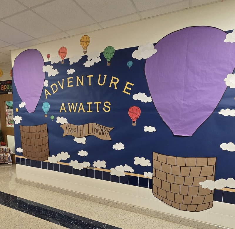 Adventure awaits in the library sign