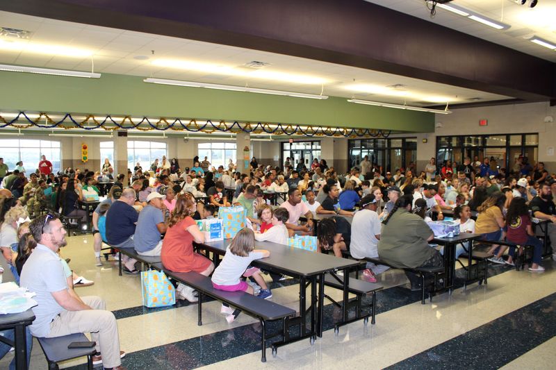 Parents and students in the cafeteria for a meeting. 