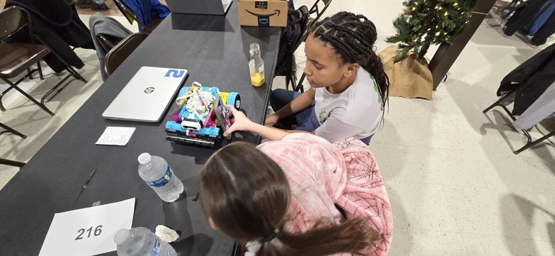 Two students inspecting their robot.
