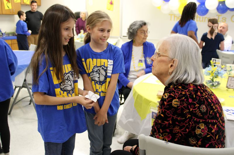 Choir students playing a game with a board member.
