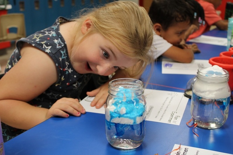 Girl smiling at a science experiment