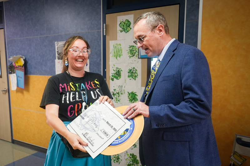 Woman smiling receiving award from Superintendent