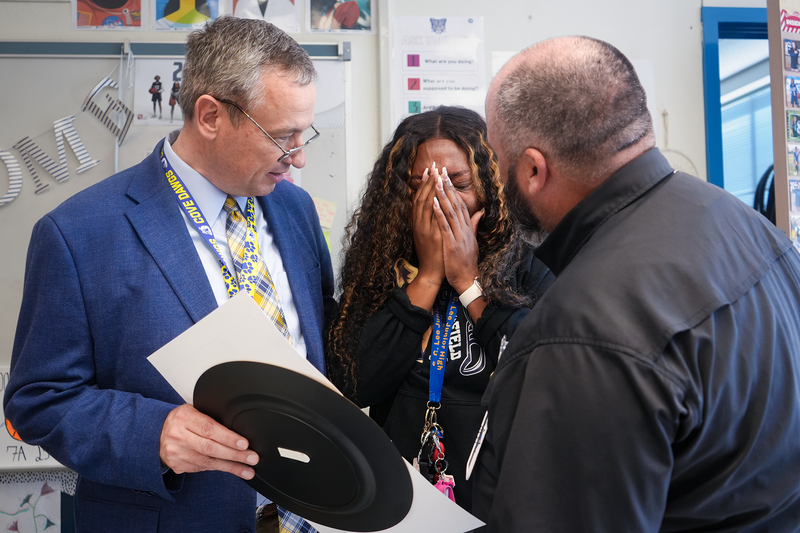 Woman crying, covering hands while receiving award from Superintendent