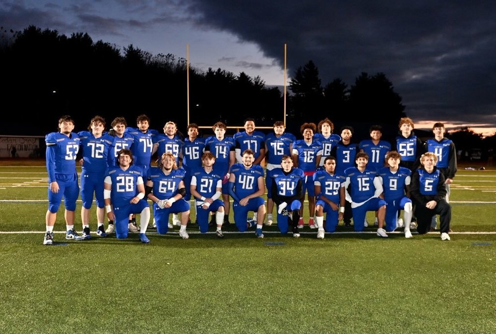 seniors on the football team in uniform posing on the field 