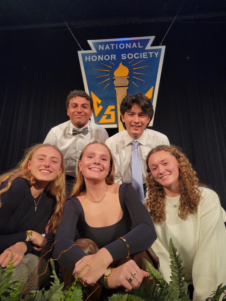 five smiling high school students in fron of a sign for National Honor Society