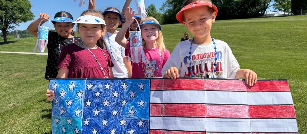 Elementary students show off their patriotic artwork before the parade