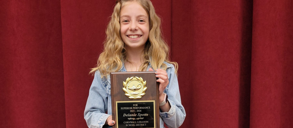 Delanie Spotts smiles for the camera while holding her Student of the Year award plaque