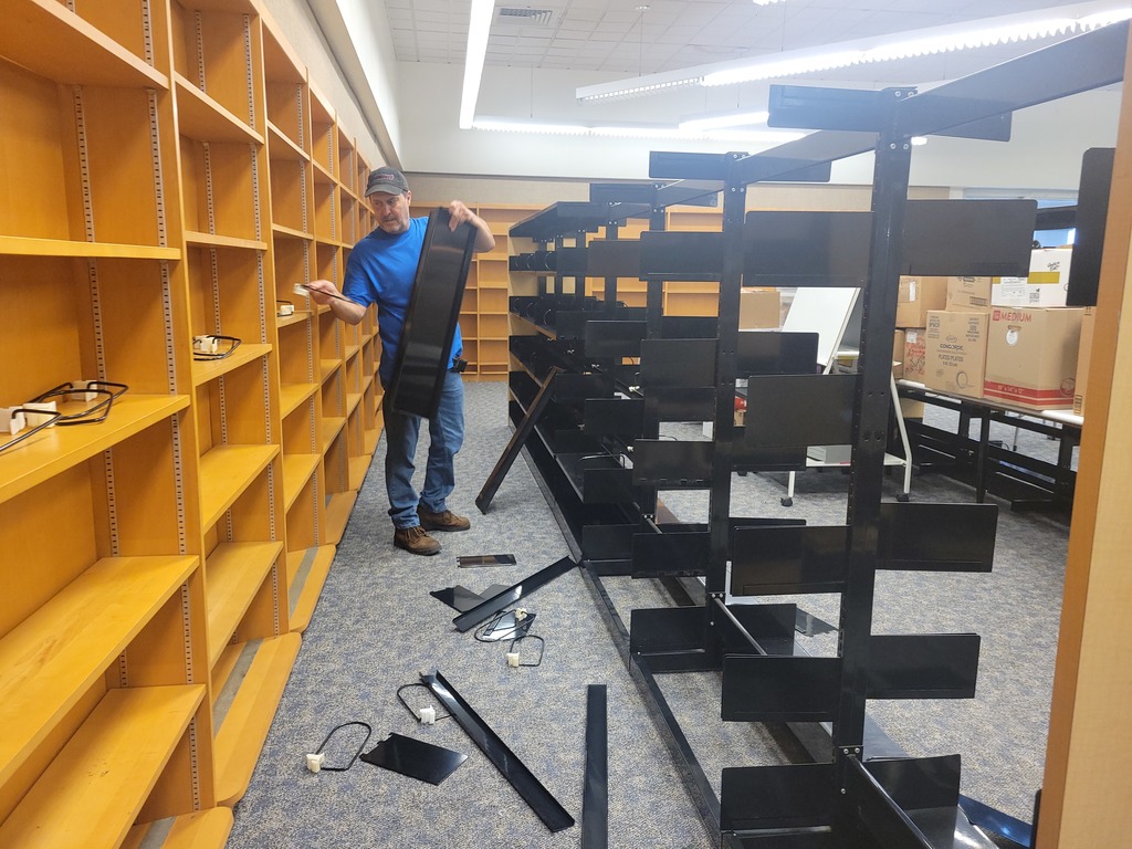 custodian dismantleing library shelves