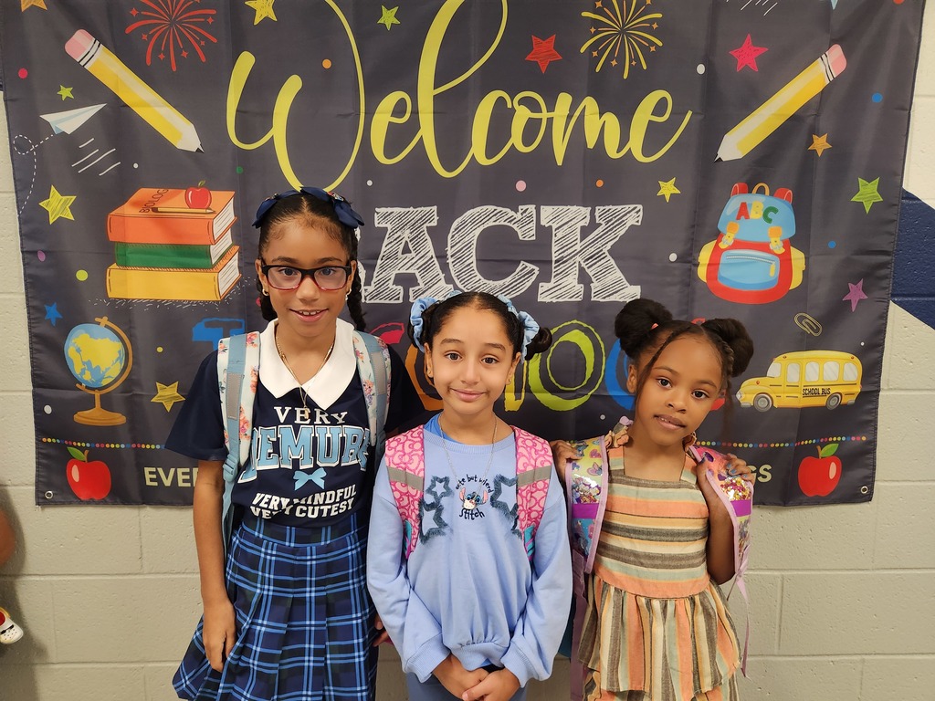 three girls in front of a Welcome Back sign