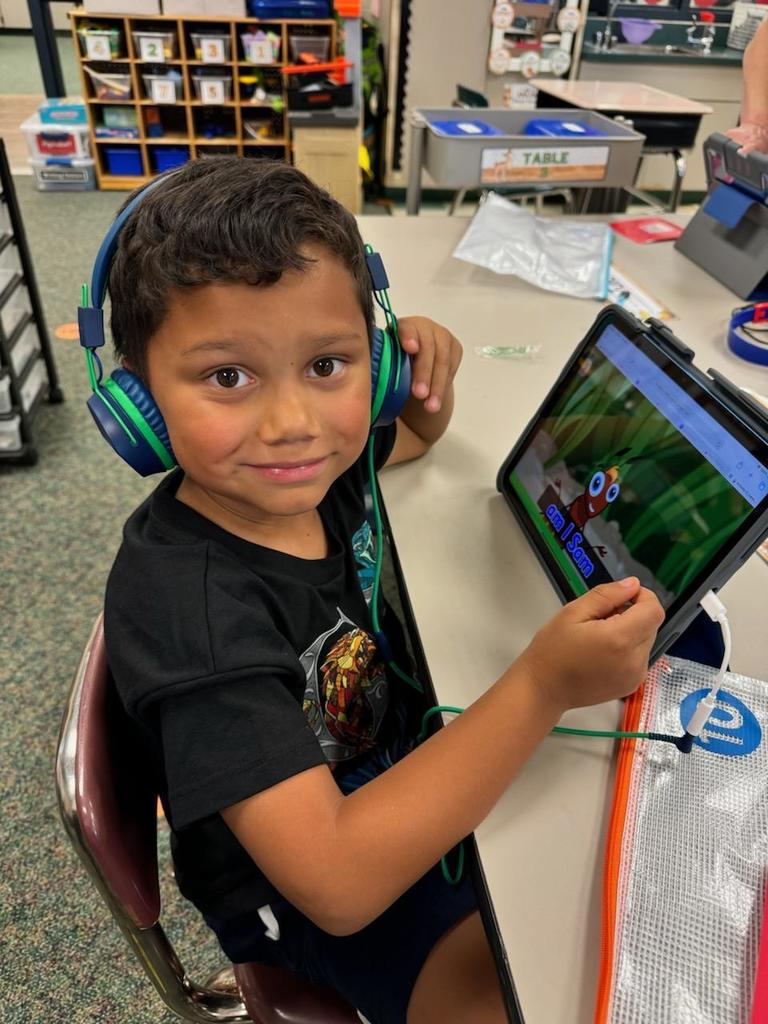young boy with headphones using 1:1 iPad