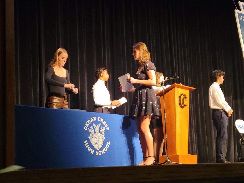 four high school students on a stage