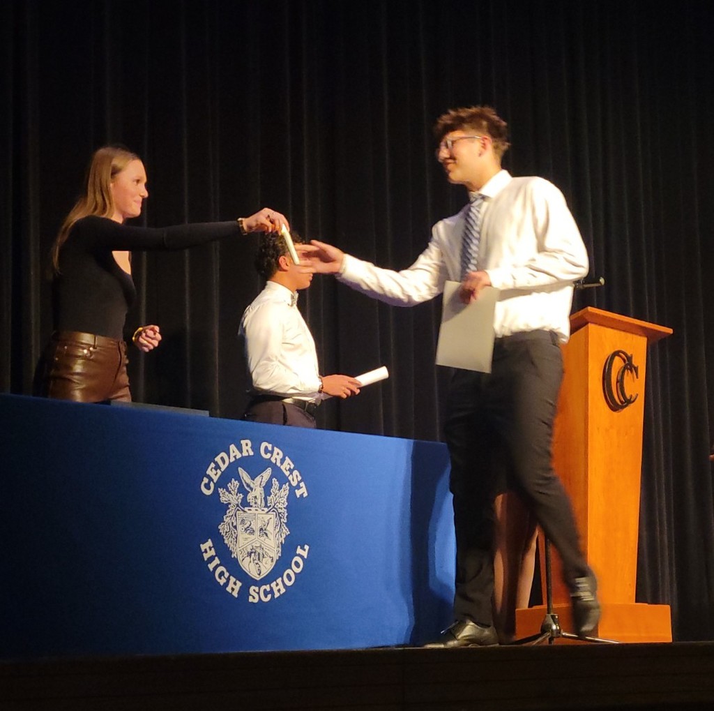 high school girl hands high school boy a candle 